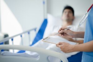 Patient on an inpatient hospital bed with a doctor examining and asking for information about the sy